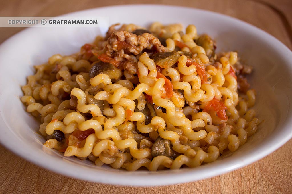 Fusilli lunghi con melanzane, salsiccia e pomodorini