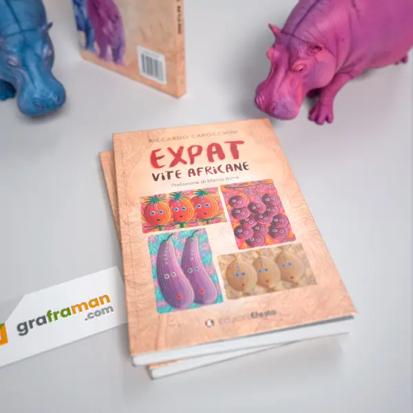 Rendering 3D ravvicinato della copertina frontale di "Expat. Vite africane" appoggiata sulle copie tra le statuine di ippopotamo - Graframan