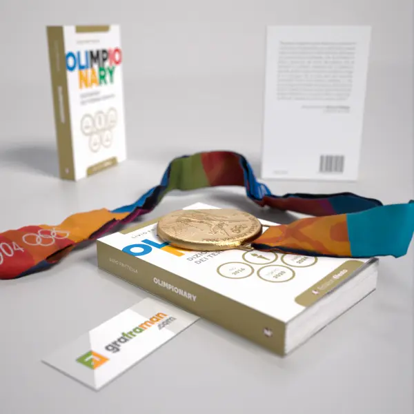 Rendering 3D della copertina di "Olimpionary" con medaglia olimpica e nastro appoggiati sopra il libro - Graframan