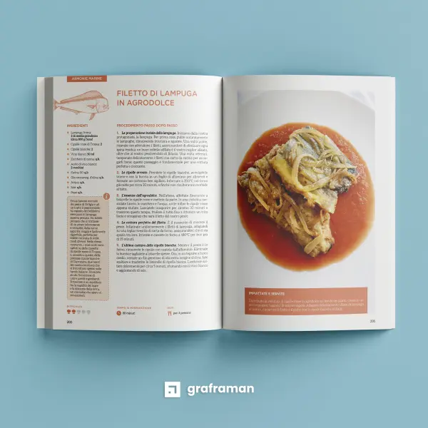 Mockup 3D del libro «Tra mare e fornelli» aperto sul «Filetto di lampuga in agrodolce», nella sezione «Armonie marine» in corallo, con il riquadro del ricordo dell'autrice sul mercato di Ortigia - Graframan